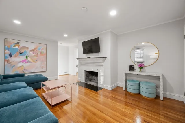 a living room with furniture mirror and a fireplace