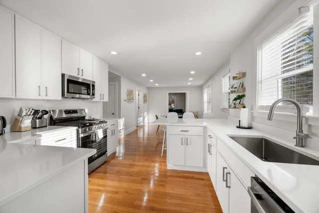 a kitchen with microwave a refrigerator and chairs