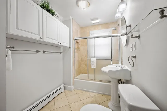 a bedroom with a bed a tv and wooden floor