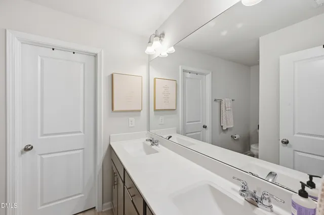 a spacious bathroom with a double vanity sink and a mirror