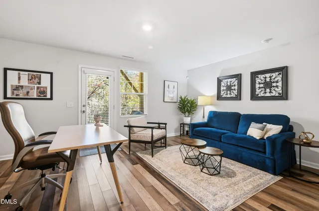 a living room with furniture and a wooden floor
