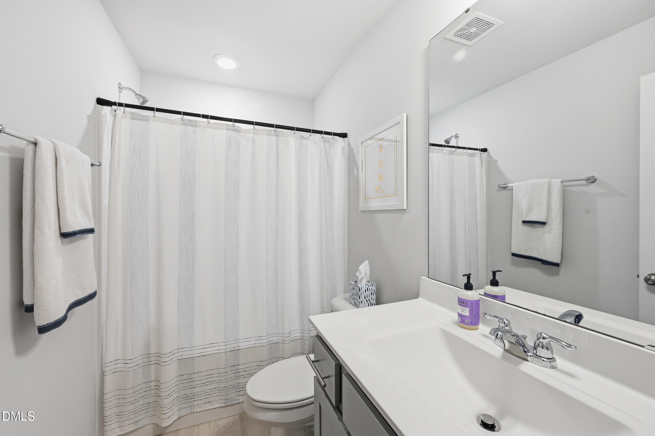2536 Laurel Valley Way Raleigh, NC 27604 - Photo 15 of 16 a bathroom with a sink a toilet a mirror and shower curtain