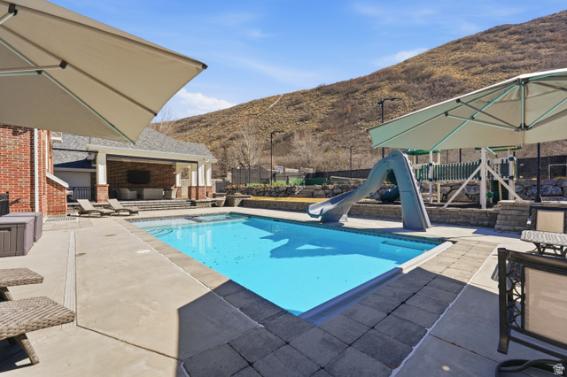 714 Draper Heights Way Draper, UT 84020 - Photo 6 of 88 View of swimming pool featuring patio surround, a water slide, and a mountain view