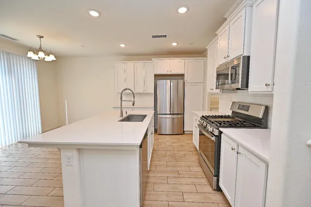 a kitchen with cabinets stainless steel appliances and a counter space