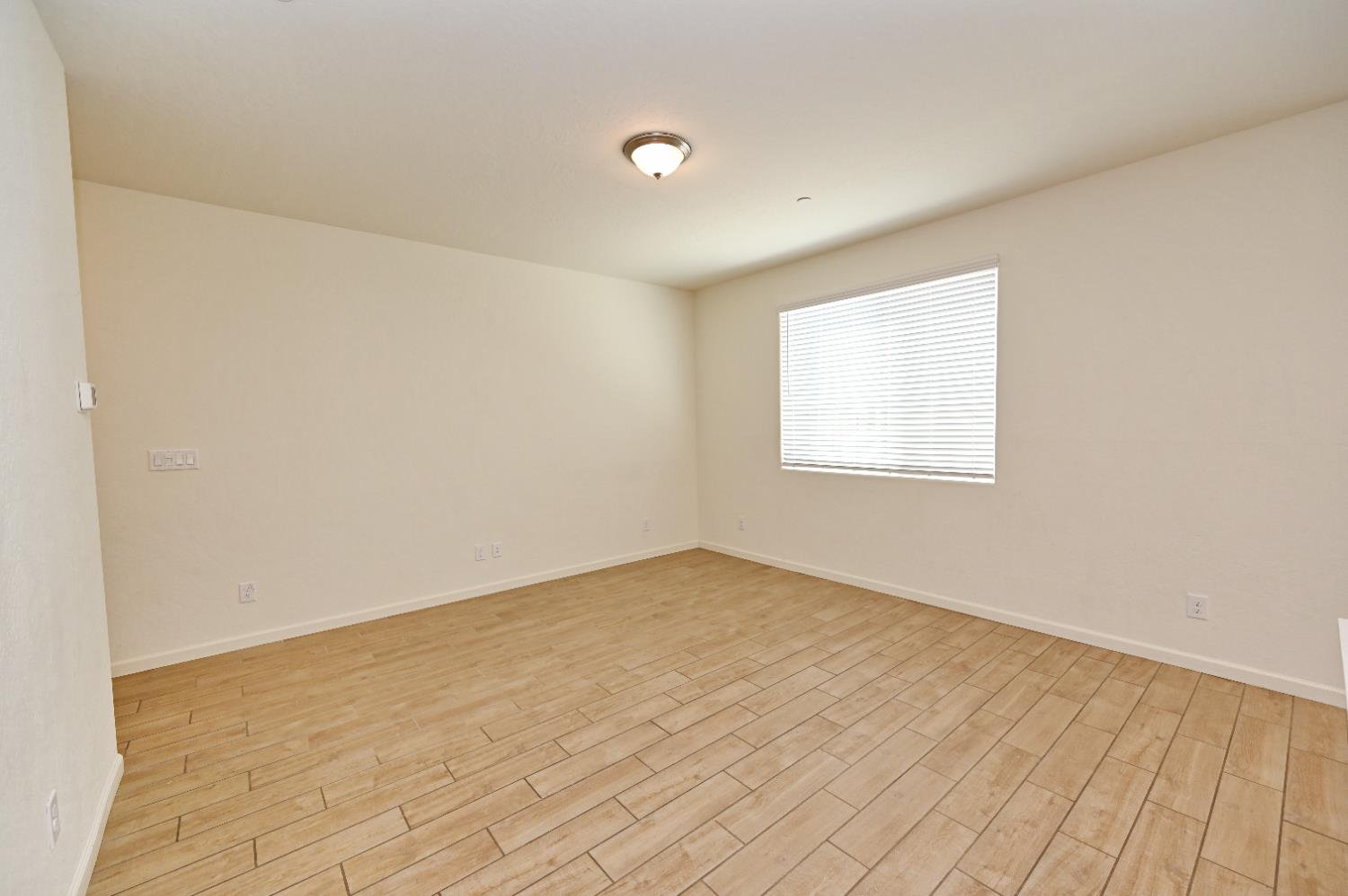 2273 North Raleigh Drive Fresno, CA 93727 - Photo 17 of 29 an empty room with wooden floor and windows