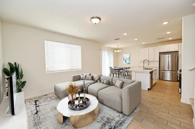 a living room with furniture kitchen and a table