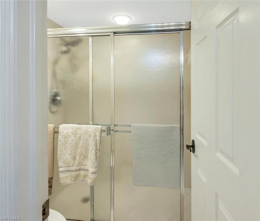 6573 Marissa Loop, Unit 1704 Naples, FL 34108 - Photo 15 of 39 a bathroom with a glass shower door