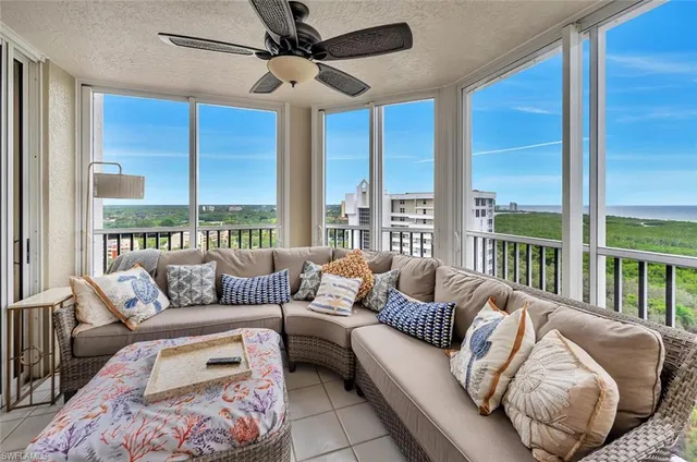 a living room with furniture and a floor to ceiling window