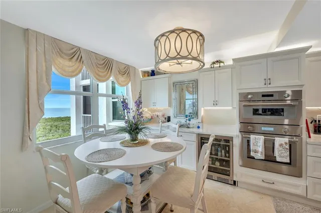 a view of a dining room with furniture a chandelier and wooden floor
