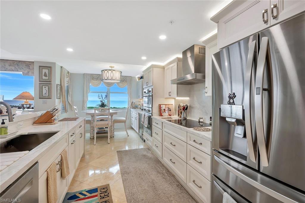 6573 Marissa Loop, Unit 1704 Naples, FL 34108 - Photo 9 of 39 a kitchen with stainless steel appliances granite countertop refrigerator sink and cabinets