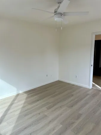 a view of an empty room with wooden floor
