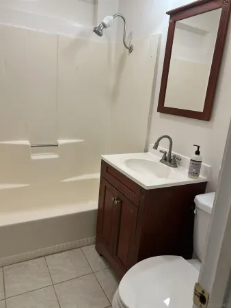 a bathroom with a sink vanity mirror and toilet