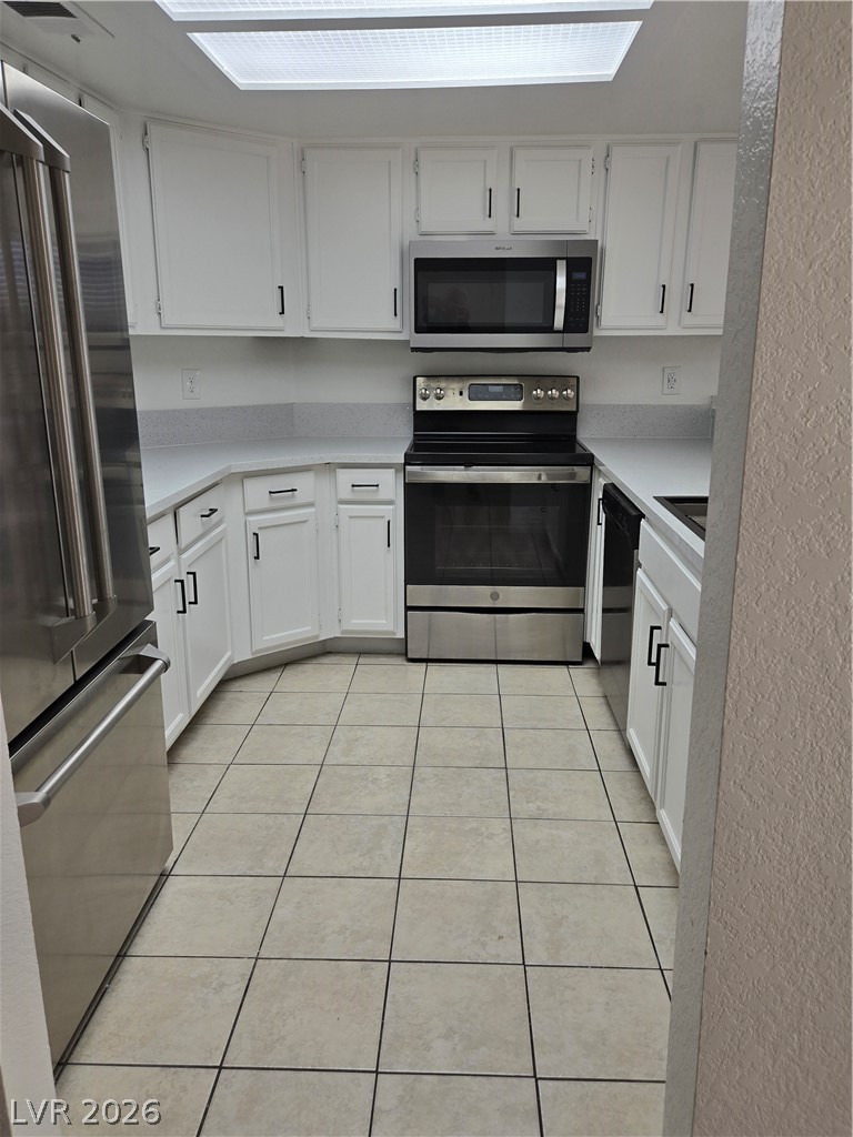 6250 West Flamingo Road, Unit 131 Las Vegas, NV 89103 - Photo 5 of 11 Gleaming stainless steel appliances complement the pristine white cabinetry and tiled flooring in this well-appointed kitchen.