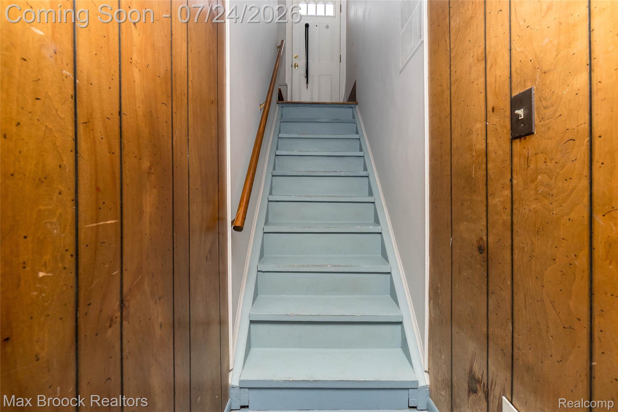 1090 Cambridge Road Berkley, MI 48072 - Photo 29 of 43 Staircase with light blue painted treads and risers, featuring a natural wood handrail