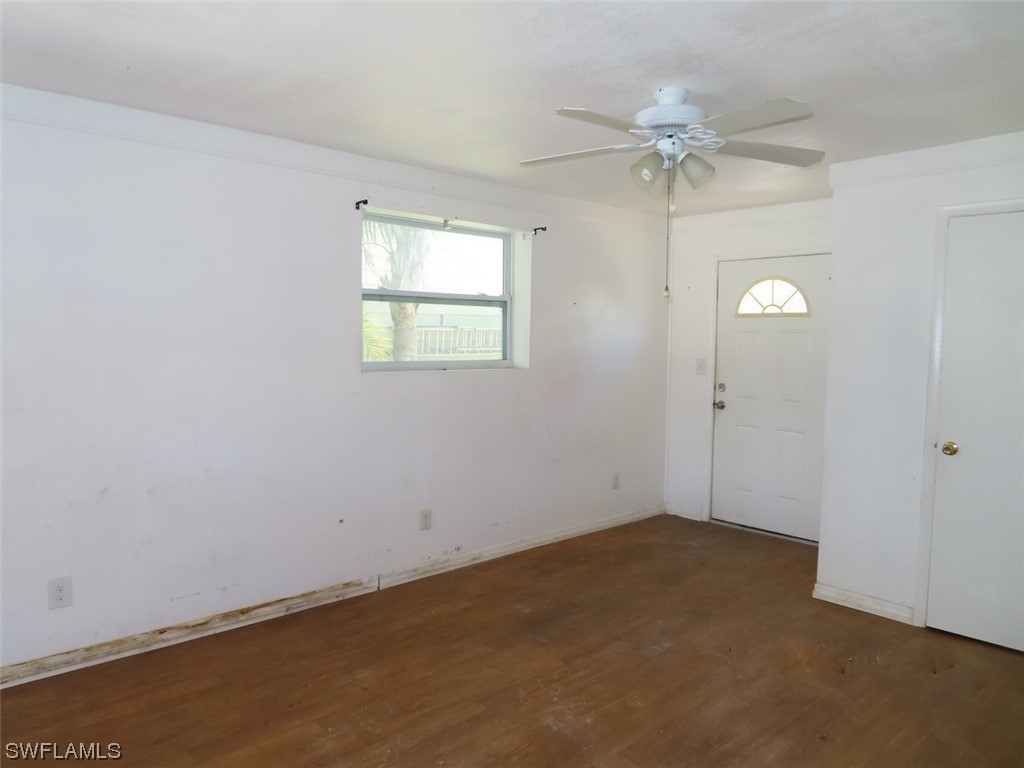 1134 6th Street Okeechobee, FL 34974 - Photo 4 of 15 an empty room with a chandelier fan and windows