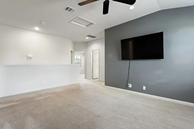 an empty room with windows and fireplace