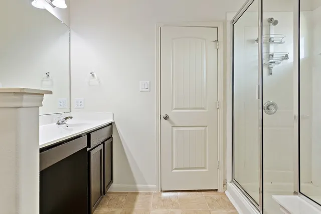 a bathroom with a shower sink and mirror