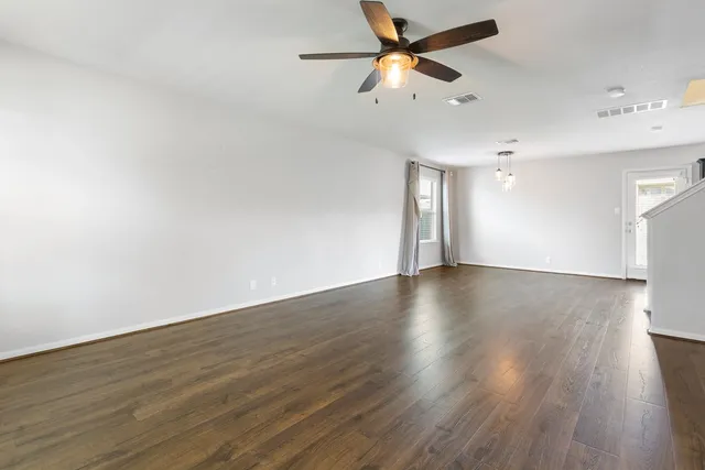 a view of a room with wooden floor and a ceiling fan