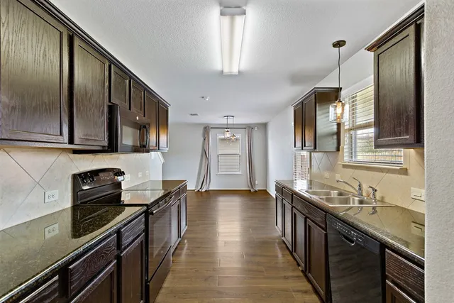 a kitchen with stainless steel appliances granite countertop a sink stove and refrigerator