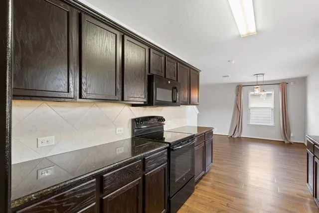 a kitchen with stainless steel appliances granite countertop a sink and wooden cabinets
