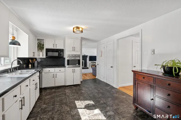 a kitchen with stainless steel appliances kitchen island granite countertop a refrigerator and a stove top oven