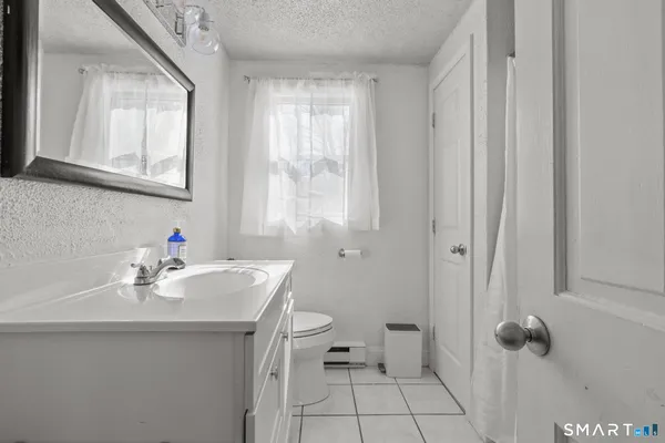 a bathroom with a sink a toilet and window