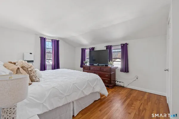 a bedroom with a bed and wooden floor