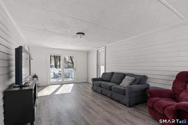 a living room with furniture wooden floor and a flat screen tv