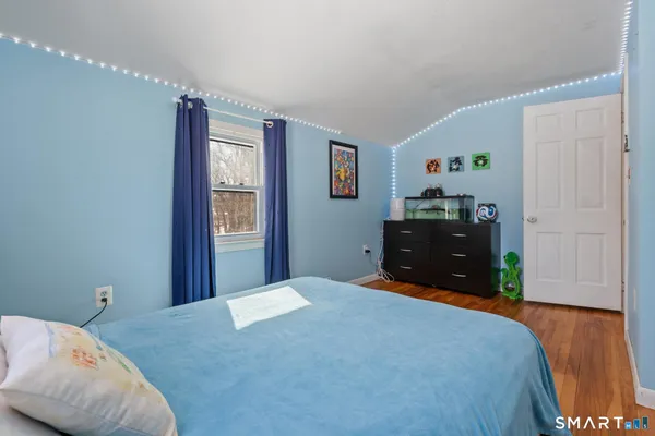 a bedroom with a bed and wooden floor