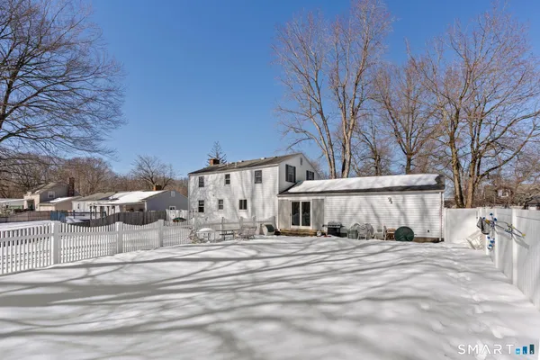 a view of a house with a yard covered in snow