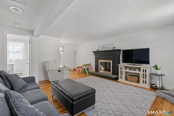 a living room with furniture a flat screen tv and a fireplace
