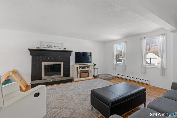 a living room with furniture a flat screen tv and a fireplace