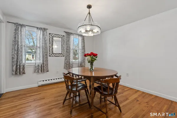 a dining room with furniture a chandelier and wooden floor