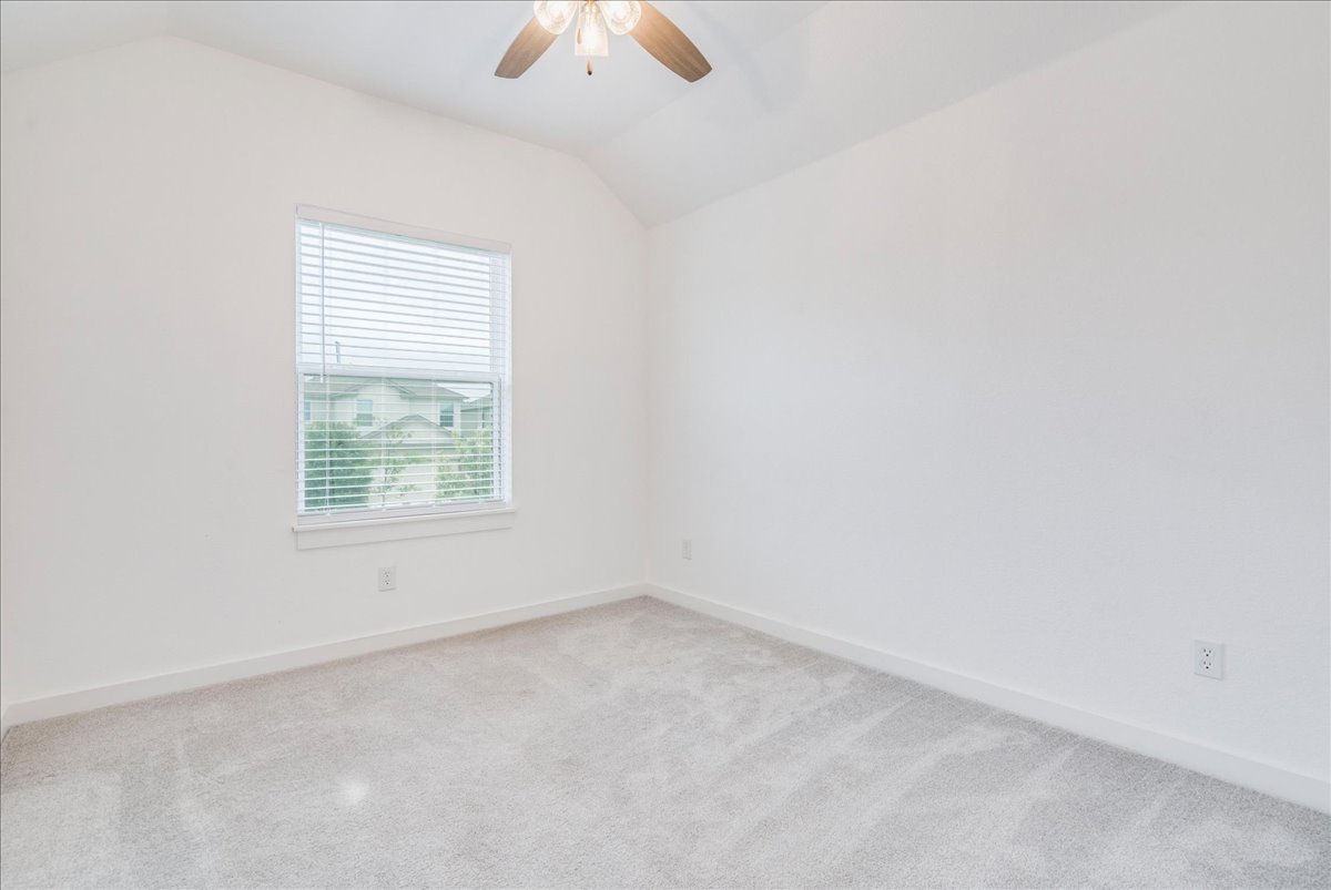 8008 Prairie Rye Drive Lago Vista, TX 78645 - Photo 14 of 40 Room with vaulted ceiling, light gray carpet flooring, and a window with horizontal blinds