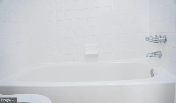 a white toilet sitting next to a bath tub