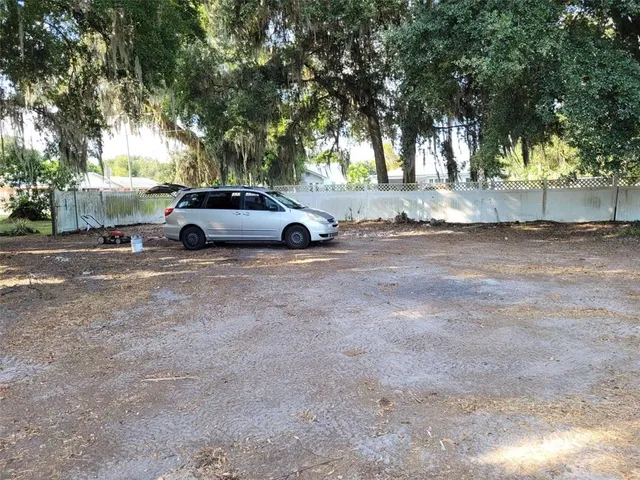 a view of a yard with trees and plants