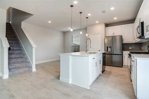 a large kitchen with cabinets a sink and stainless steel appliances