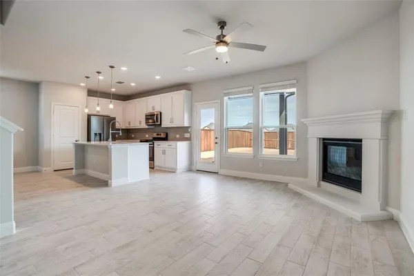 a view of a kitchen with a sink fire place and an empty room