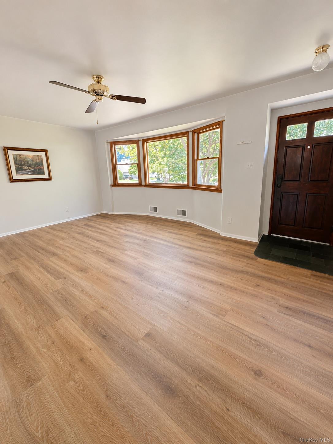 16 Clay Pitts Road Greenlawn, NY 11740 - Photo 3 of 25 Interior Family room featuring wood-finish flooring, a bay window with natural wood trim, and a ceiling fan