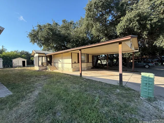 a view of a house with backyard and sitting area
