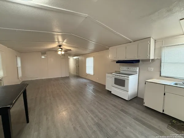 a kitchen with a sink cabinets and wooden floor