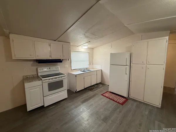a kitchen with white cabinets and white appliances