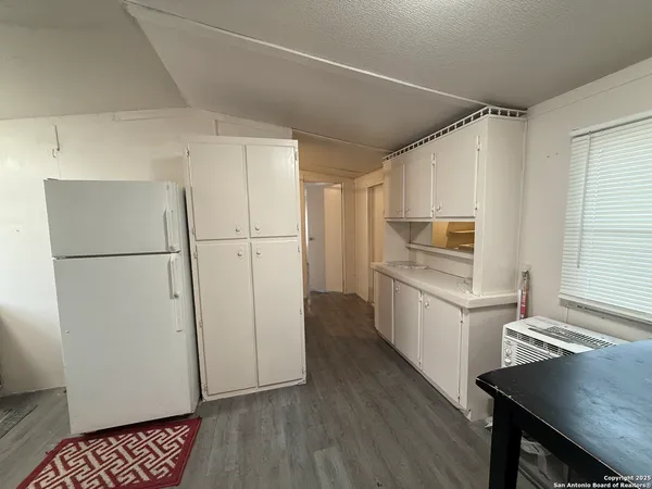 a kitchen with a refrigerator a sink and cabinets