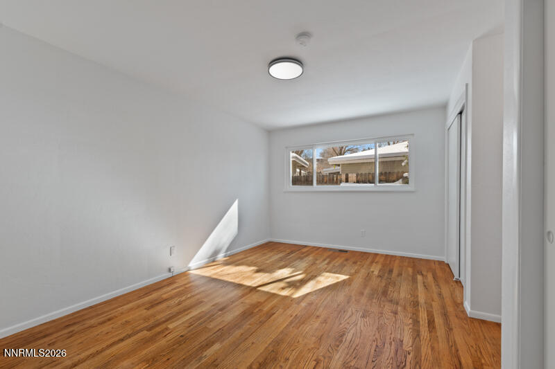 810 Lahontan Way Reno, NV 89509 - Photo 11 of 25 an empty room with wooden floor and windows
