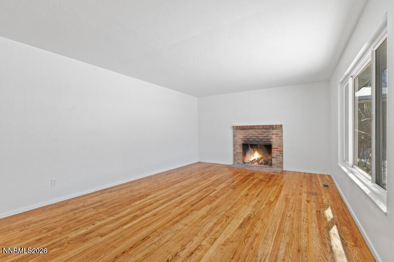 810 Lahontan Way Reno, NV 89509 - Photo 5 of 25 a view of empty room with wooden floor and fireplace