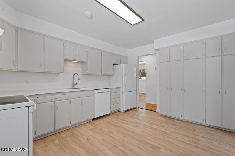 810 Lahontan Way Reno, NV 89509 - Photo 8 of 25 a kitchen with white cabinets and wooden floors