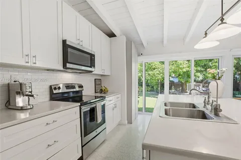 a kitchen with granite countertop a sink and steel appliances