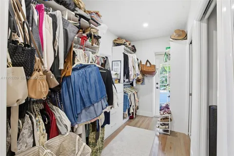a view of walk in closet with clothes and shoes