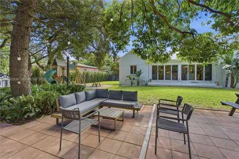 a view of house with backyard outdoor seating and green space