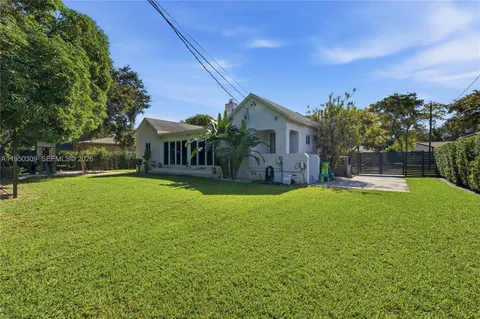 a view of a house with backyard and a tree